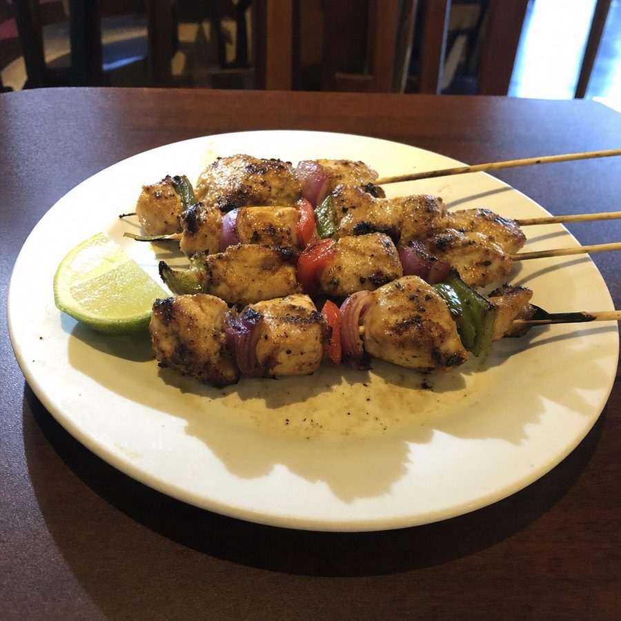 Grilled chicken skewers under harsh, uneven mixed light before editing