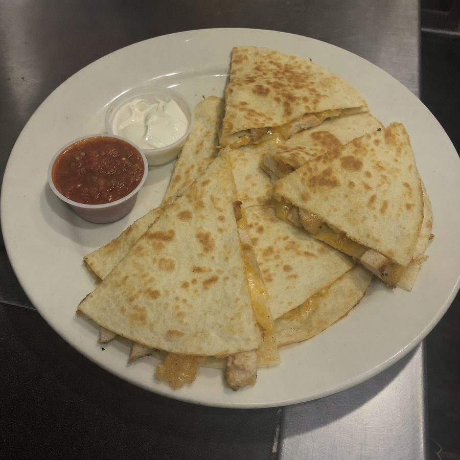 Quesadillas photographed in dark, low-contrast kitchen light, the kind of dim photo DoorDash rejects