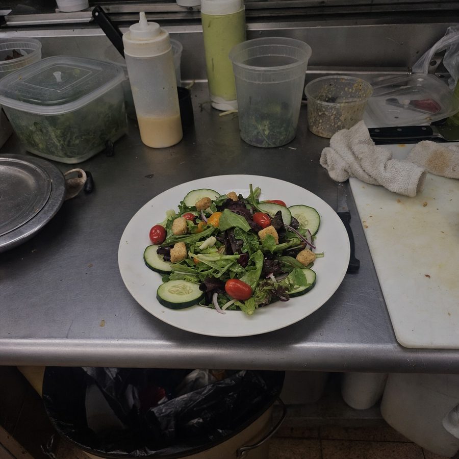 Restaurant salad photographed on a cluttered prep counter before styling