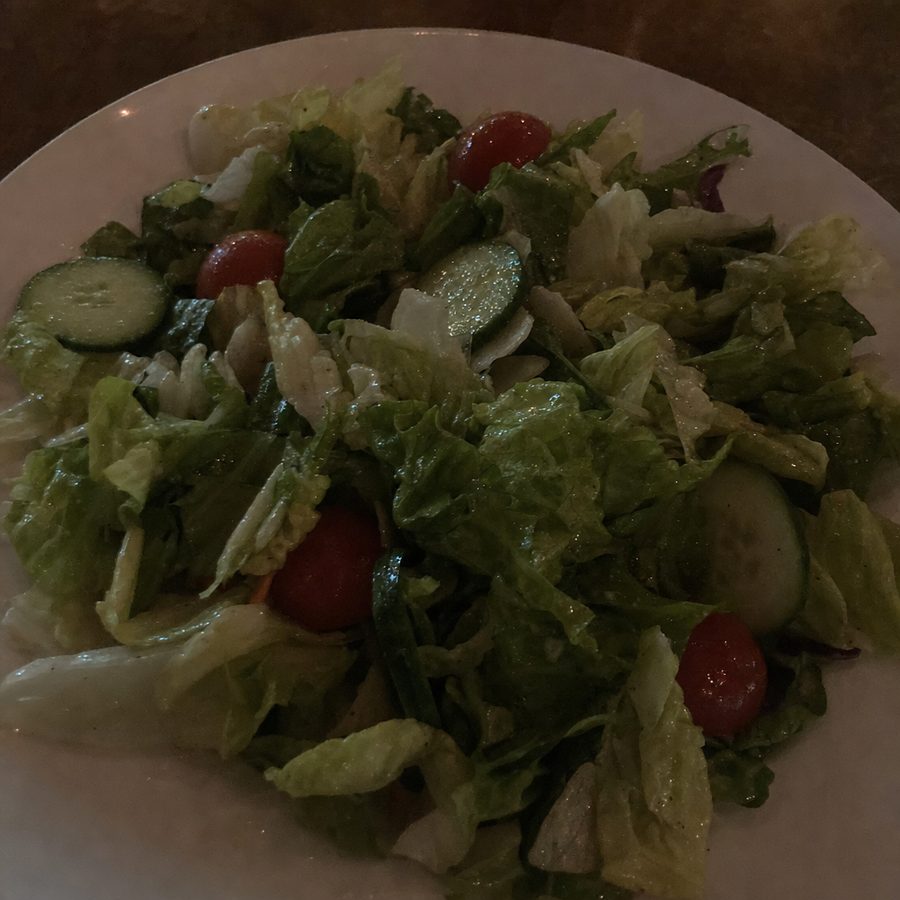 Salad photographed under dark underexposed restaurant lighting before correction