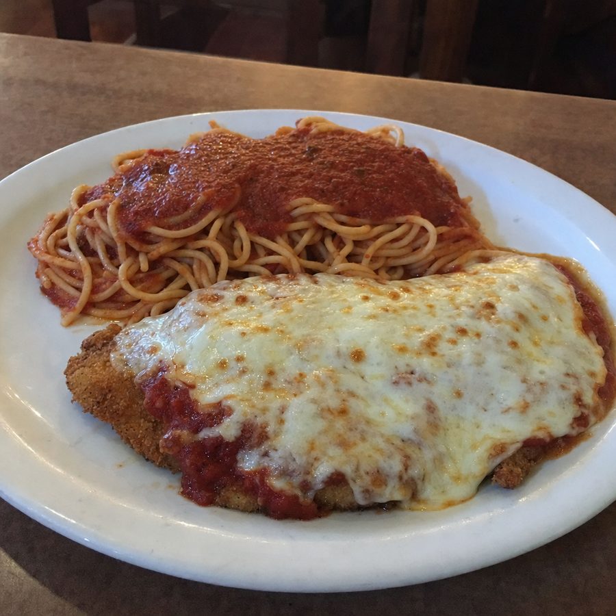 Ordinary flat, dull phone photo of a plate of chicken parmesan with spaghetti
